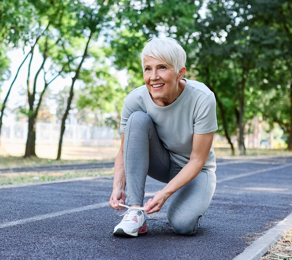 Starija žena u sportskoj opremi se sprema za džoging.