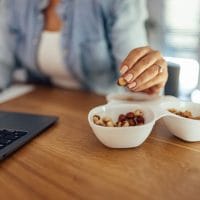 Žena na poslu gricka orašaste plodove.