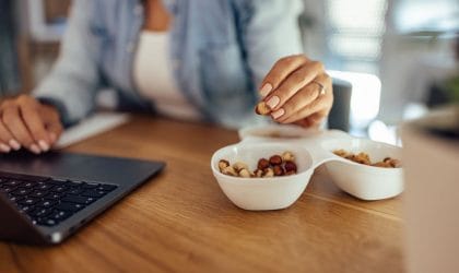 Žena na poslu gricka orašaste plodove.