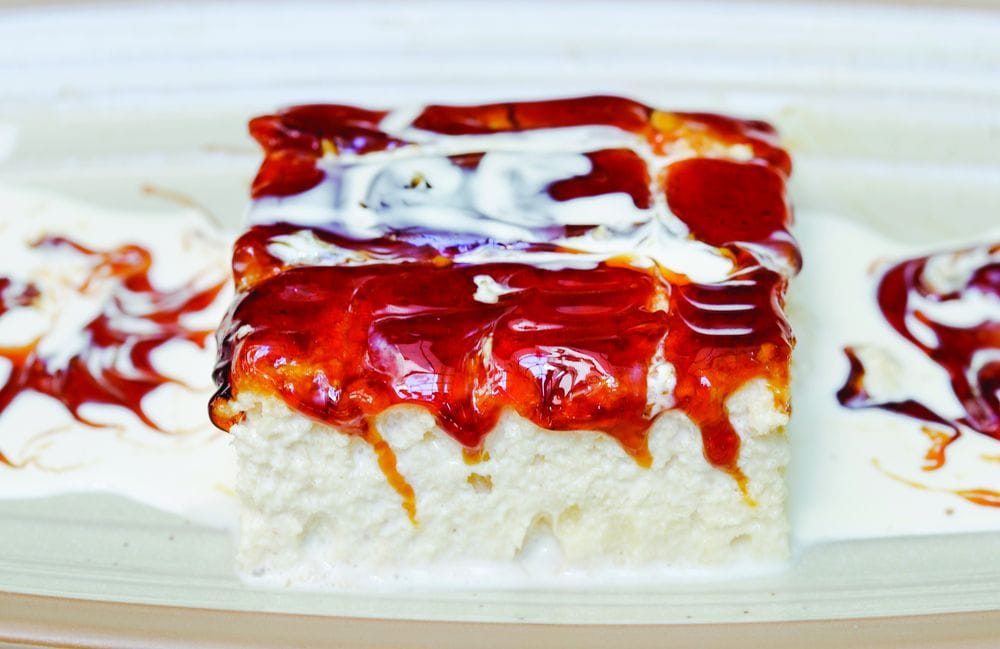 Komad tri lece kolača sa bogatim karamel prelivom.