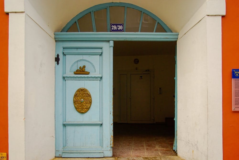 Starinska vrata koja su poluotvorena, a unutra u otvoru se nazire tama.