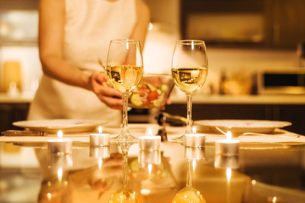 Žena postavlja sto za romantičnu večeru kod kuće,