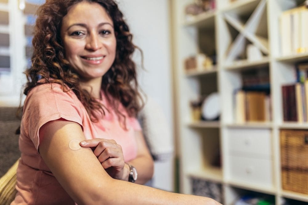 Žena koja na nadlaktici nosi hormonski flaster.