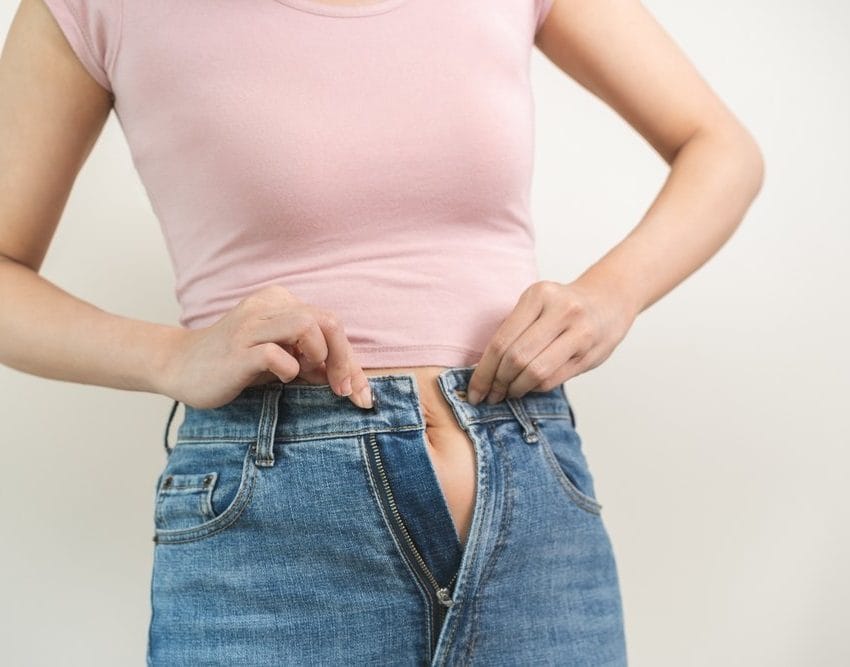 Žena koja je normalne građe ima problem da zakopča farmerke.