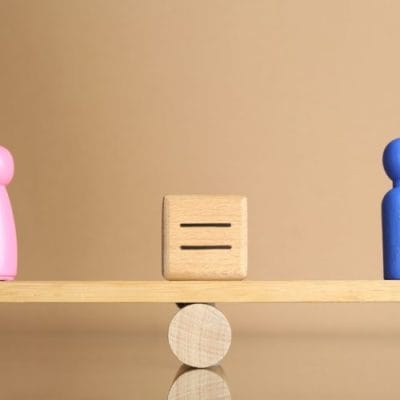 Muska i zenska figura na klackalici u balansu.