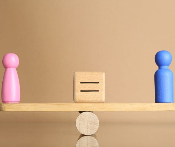 Muska i zenska figura na klackalici u balansu.