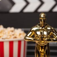 Oskar statua i crveno-bela čaša sa kokicama.