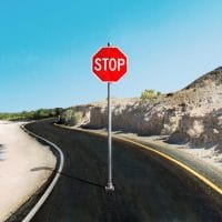 Put pored mora i peščane plaže, na sred puta stoji ili je postavljen veliki saobraćajni znak stop.