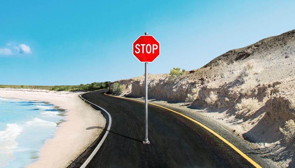 Put pored mora i peščane plaže, na sred puta stoji ili je postavljen veliki saobraćajni znak stop.