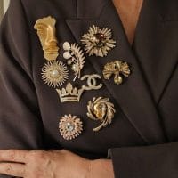 Grupa bro[eva uglavnom u zlatnoj boji sa biserima ili kristalima na levom reveru sakoa.