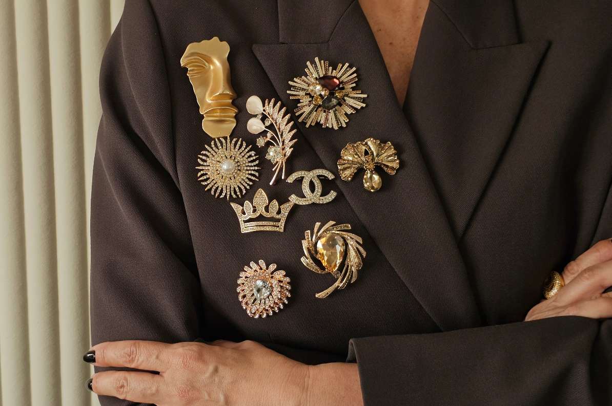 Grupa bro[eva uglavnom u zlatnoj boji sa biserima ili kristalima na levom reveru sakoa.