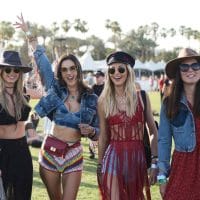 Devojke na muzičkom festivalu u Koačeli, nose kaubojske šešire, kratke šorceva, topove koj iotkrivaju stomak ili su sa resama.