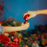 Mama i dete se kucaju jcrvenim jajim za Uskrs.