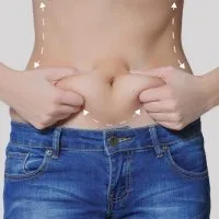 Žena u farmerkama, gornji deo tela je go, rukama drži salo koje se formiralo na stomaku.