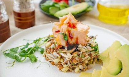 Salata od proklijalih semenki na kojoj su servirani komadi dimljene pastrmke.
