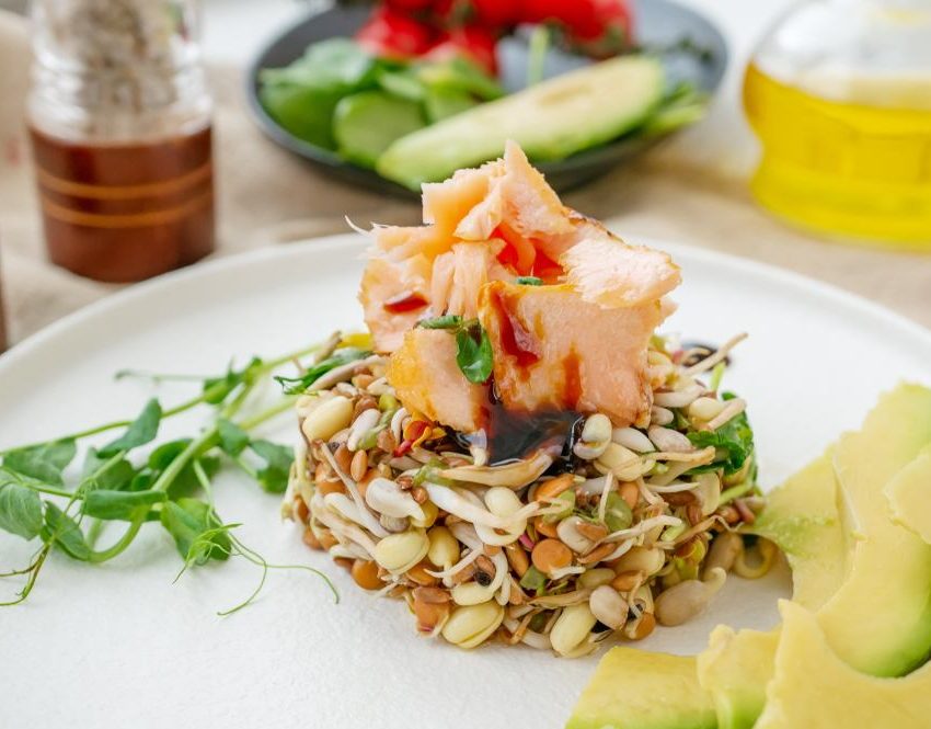 Salata od proklijalih semenki na kojoj su servirani komadi dimljene pastrmke.