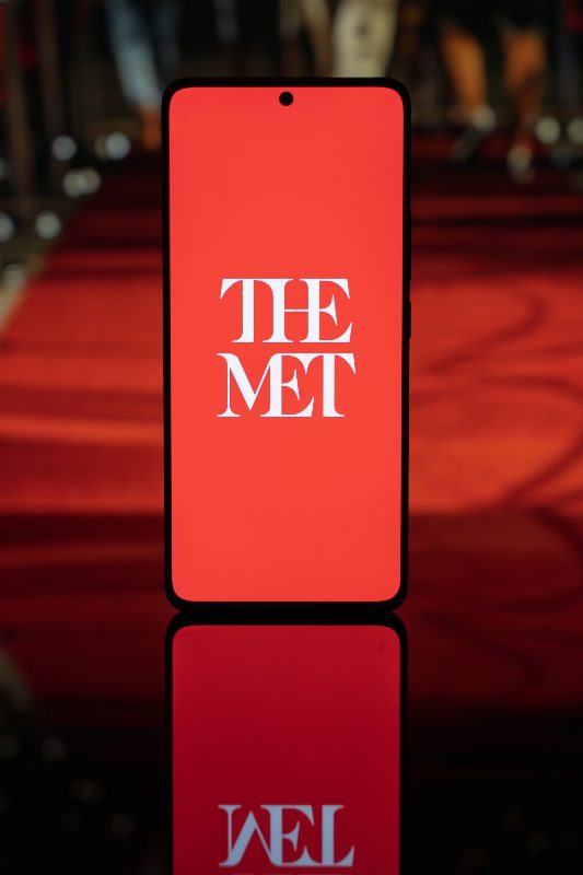 Natpis na ekranu mobilnog telefona The Met, belim slovima na crvenoj pozadini.