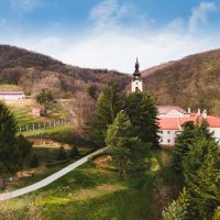 Jedan od manastira na Fruskoj gori, okružen zelenilom.