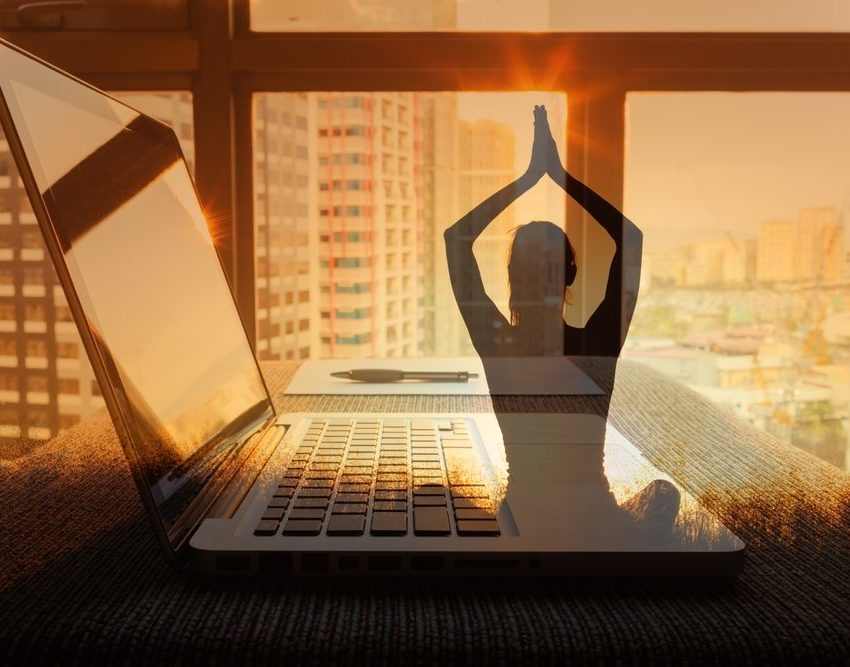 Fotografija ilustracija, lap top na stolu, kroz prozor se vidi grad. Preko fotografije je ilustracija žene koja radi jogu.