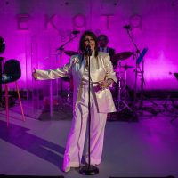 Yasmin Levi na bini u amfiteatru Ekata estate-a. U pozadini je ružičasto svetlo. Yasmin je u belom odelu.