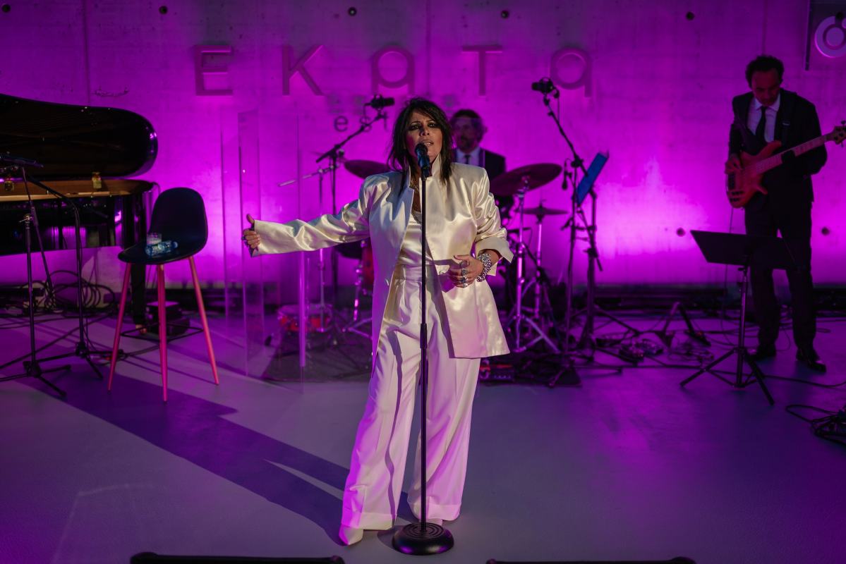 Yasmin Levi na bini u amfiteatru Ekata estate-a. U pozadini je ružičasto svetlo. Yasmin je u belom odelu.