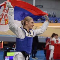 ANdrea Bokan u dresu sa podignutom srpskom zastavom.