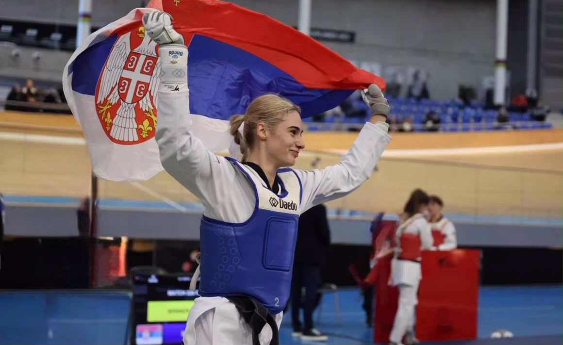 ANdrea Bokan u dresu sa podignutom srpskom zastavom.