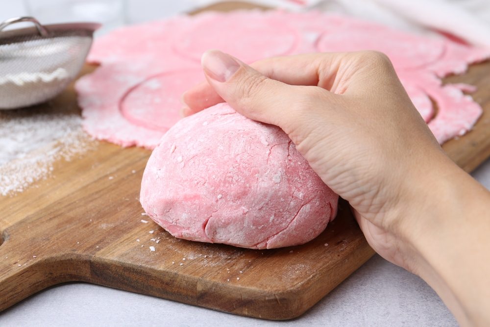Žena rasteže rozikasto testo koje se koristi za pravljenje mochi kolačića i oblikuje ga.