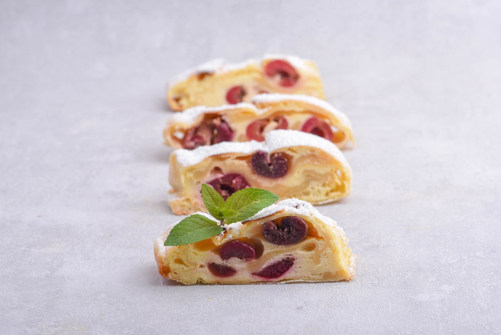 Komadići pite od višanja, vidljivi između kore i fila od pudinga od vanile.