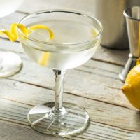 Martini Vesper koktel u ;a[i, pored je limun sa koga je olju[ten deo kore za ukrašavanje.