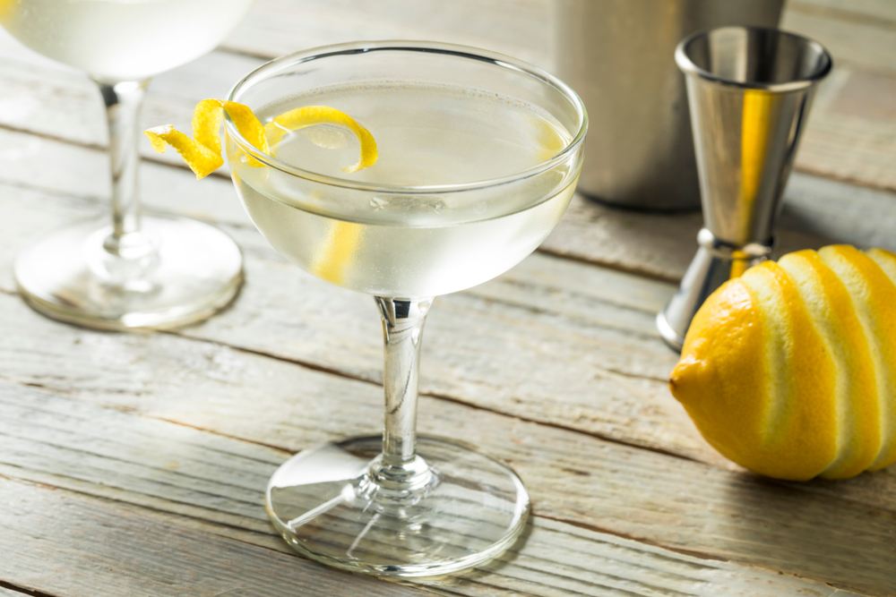 Martini Vesper koktel u ;a[i, pored je limun sa koga je olju[ten deo kore za ukrašavanje.