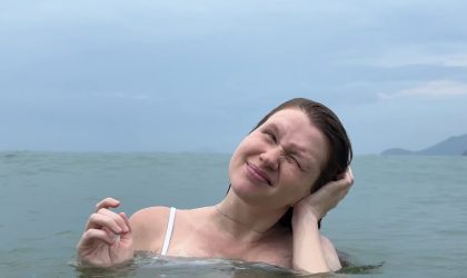Devojka u moru, nagla je glavu na jednu stranu, leva ruka joj je na uhu.