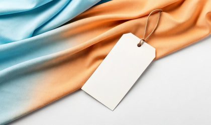 Etiketa za garderobu prika;ena na fini oranž-plavi materijal, na kojoj ništa ne piše.
