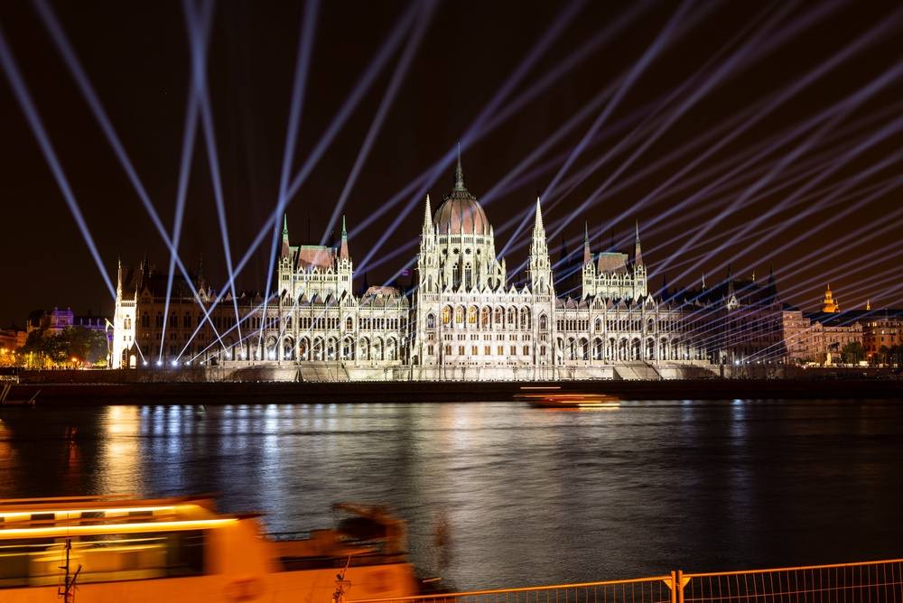 Parlament noću, obasjan neobičnim svetlima.
