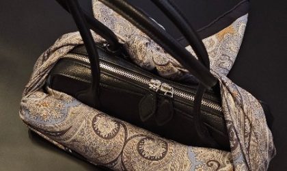 Kišobran upakovan u elegantnu maramu i prikačen, zavezan za tašnu.