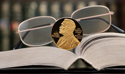 Otvorena knjiga na kojoj stoje naočare i Nobelova nagrada.