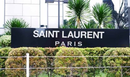 Crna tabla u zelenilu na kojoj piše Saint Laurent, Paris.