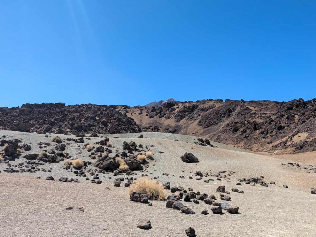 Predeo oko vulkana Teide, crno kamenje i pesak.